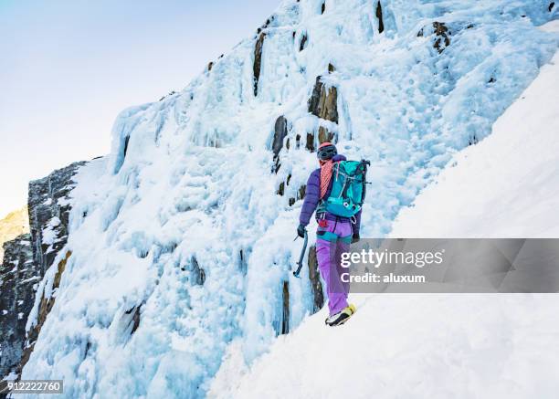 weibliche eiskletterer vor gefrorenen wasserfall pyrenäen frankreich - cascade france stock-fotos und bilder