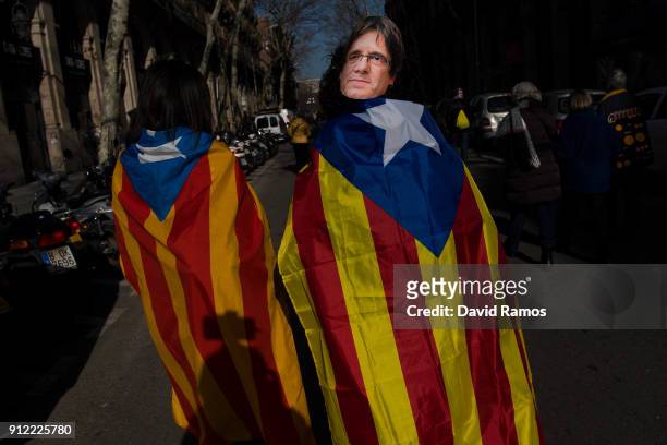 Woman draped in a Catalonia's Pro-independence flag know as 'Estelada' and wearing a cut-out mask of the former Catalan President, Carles Puigdemont...