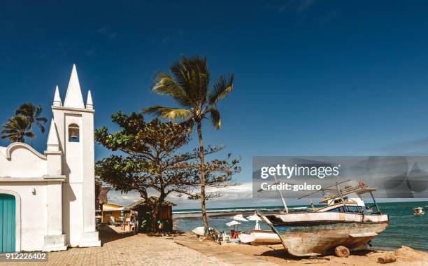 fishing boat in the sand of praia do forte beach in the sun - brazil village stock pictures, royalty-free photos & images