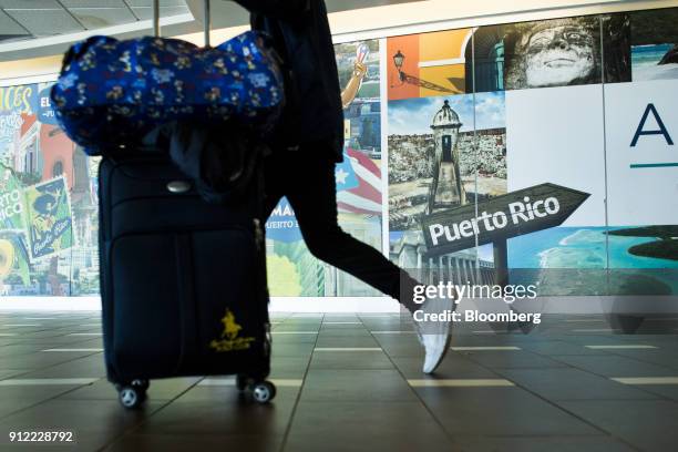 Traveler pushes luggage through Luis Munoz Marin International Airport in Carolina, Puerto Rico, on Sunday, Jan. 21, 2018. Before Hurricane Maria...