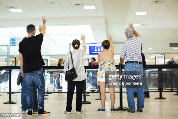 People wave to travelers going through security at Luis Munoz Marin International Airport in Carolina, Puerto Rico, on Sunday, Jan. 21, 2018. Before...