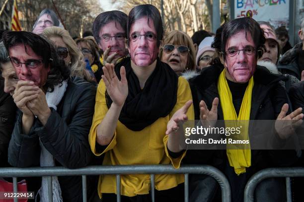 Demonstrators wear cut-out masks of the former Catalan President, Carles Puigdemont as they take part in a protest on January 30, 2018 in Barcelona,...