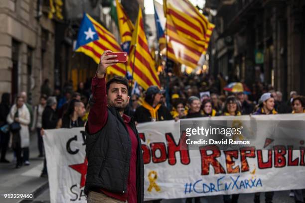 Man takes a selfie in front of a demonstration to support former Catalan President, Carles Puigdemont on January 30, 2018 in Barcelona, Spain. The...