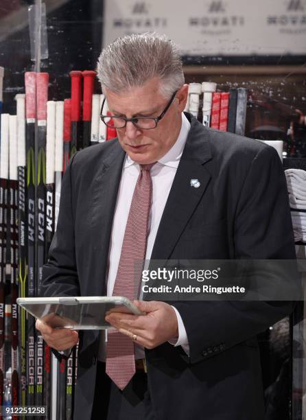 Assistant coach Marc Crawford of the Ottawa Senators works on an iPad during an NHL game against the Boston Bruins at Canadian Tire Centre on January...