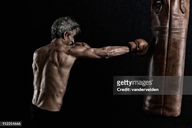 gråhåriga pensionerad boxare svettning under hans träning - boxboll bildbanksfoton och bilder