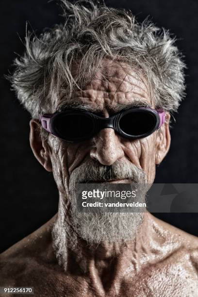 grijs-haired mens zwemmen bril dragen - vandervelden stockfoto's en -beelden