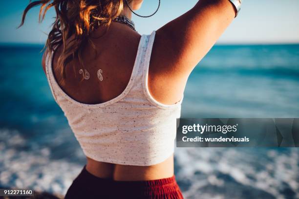 年輕的波希米亞女孩在海灘上的紋身放鬆 - 臨時 個照片及圖片檔