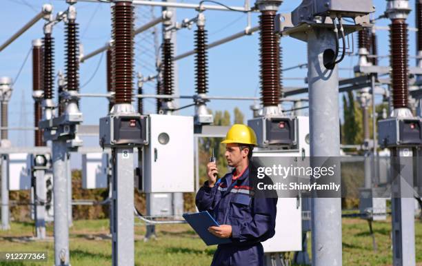 trabajador en la planta de energía. hablando para el talkie walkie - corriente-de-alto-voltaje fotografías e imágenes de stock