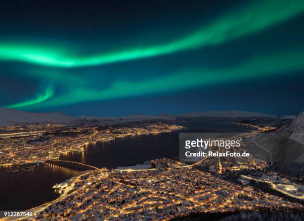 luftaufnahme in der nacht vom storsteinen hill auf tromsø stadt mit schönen formen der aurora borealis - tromsö stock-fotos und bilder