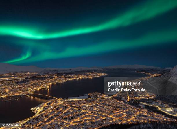 aerial view at night from storsteinen hill on tromso city with beautiful shapes of aurora borealis - tromso stock pictures, royalty-free photos & images