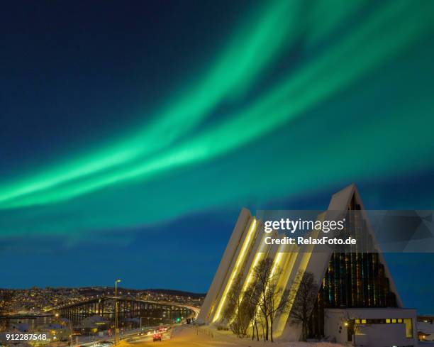 verlichte tromsø kathedraal at night met prachtige groene vormen van aurora borealis - kathedraal stockfoto's en -beelden