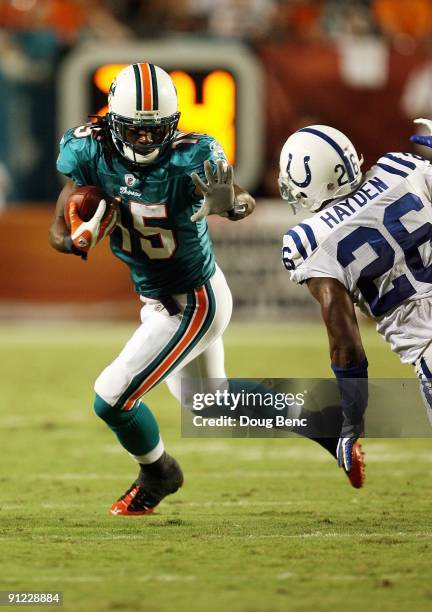 Wide receiver Davone Best of the Miami Dolphins looks looks to avoid a tackle attempt by defensive back Kelvin Hayden of the Indianapolis Colts at...