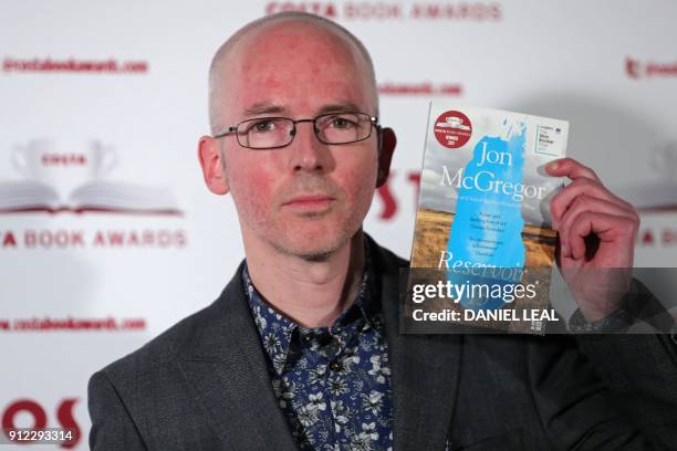 British author Jon McGregor poses with his 'Novel' Award winning book 'Reservoir 13' as he arrives for the 2017 Costa Book Awards in London on...