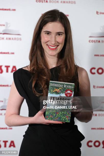 British author Katherine Rundell poses with her 'Children's Book' Award winning book 'The Explorer' as she arrives for the 2017 Costa Book Awards in...