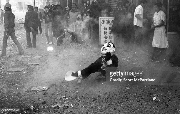 Masked street performer dances on the sidewalk, as firecrackers explode all around him during the annual Chinese New Year celebrations in Chinatown,...