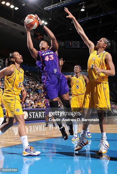 Le'coe Willingham of the Phoenix Mercury goes up for a shot against Tina Thompson and Candace Parker of the Los Angeles Sparks in Game One of the...