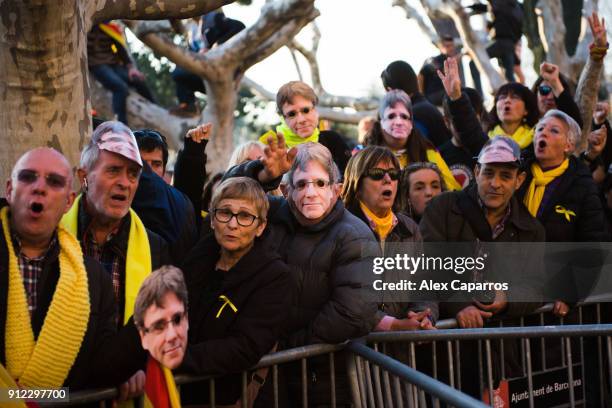 Demonstrators wear cut-out masks of the former Catalan President Carles Puigdemont as they take part in a protest in front of the Parliament of...