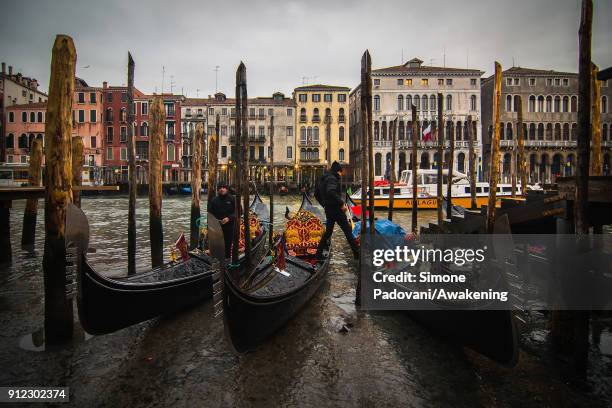 Gondolers leave their gondolas along the Grand Canal near Rialto bridge because of an exceptional low tide on January 30, 2018 in Venice, Italy. An...