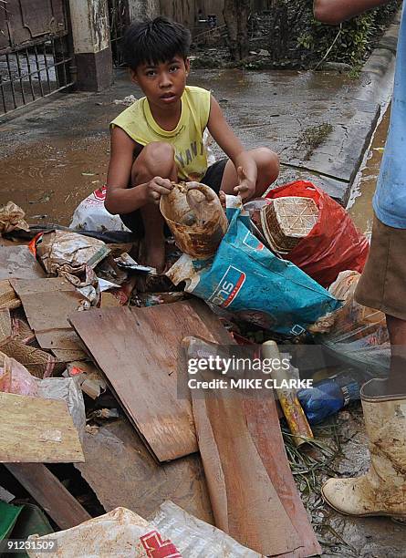 Children scavenge thorugh debris for plastic which they can sell for around 40 US Cents a kilo in the aftermath of flooding in Cantas Town on the...