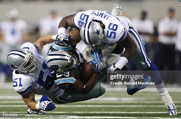 Jonathan Stewart of the Carolina Panthers gets tackled by Bradie James and Keith Brooking of the Dallas Cowboys at Cowboys Stadium on September 28,...