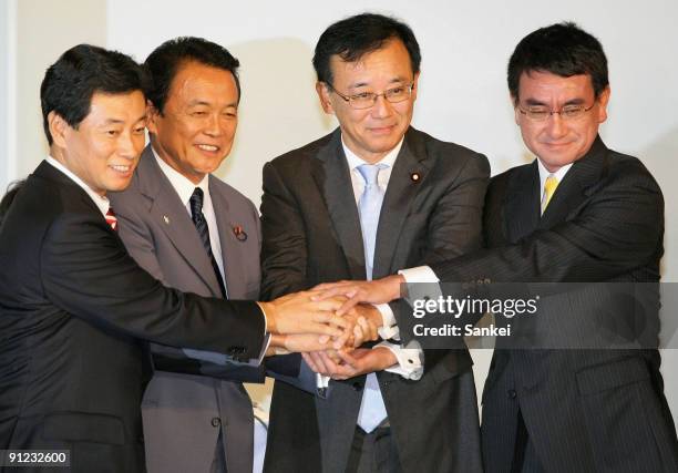 Candidate Yasutoshi Nishimura, outgoing President Taro Aso, newly elected President Sadakazu Tanigaki and candidate Taro Kono shake hands after...