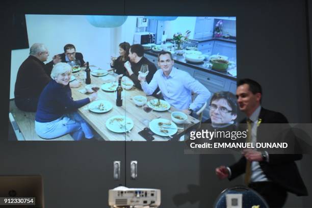 Picture shows a screen displaying displaying ousted Catalan separatist leader Carles Puigdemont eating a meal during a broadcast at the New Year...