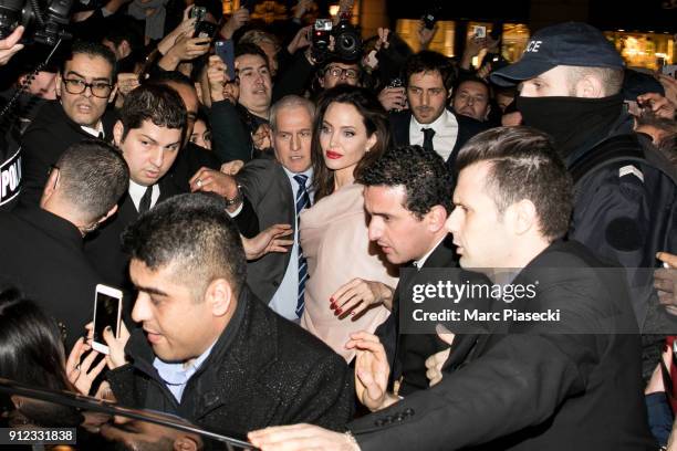 Actress Angelina Jolie is surrounded by the crowd as she leaves the 'Guerlain' store on the Champs-Elysees avenue on January 30, 2018 in Paris,...