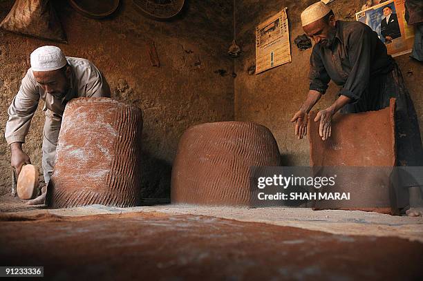 Afghan men make 'tandur' ovens at their shop in Kabul on September 29, 2009. Despite a flood of billions of dollars in aid provided by the...