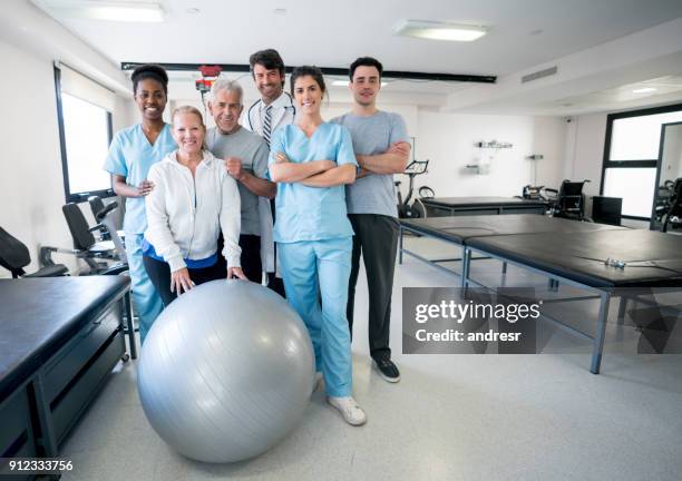 vielfältigen team von angehörigen der gesundheitsberufe und patienten auf eine physische reha-klinik - physical therapist stock-fotos und bilder