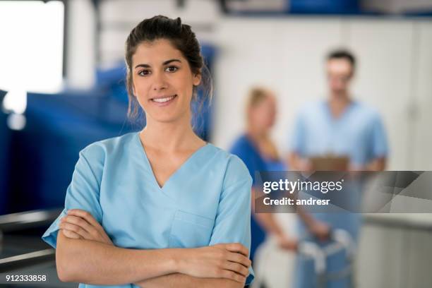 hübsche lateinamerikanischen physiotherapeut bei einer reha-klinik, blick auf die kamera zu lächeln - ergotherapie stock-fotos und bilder