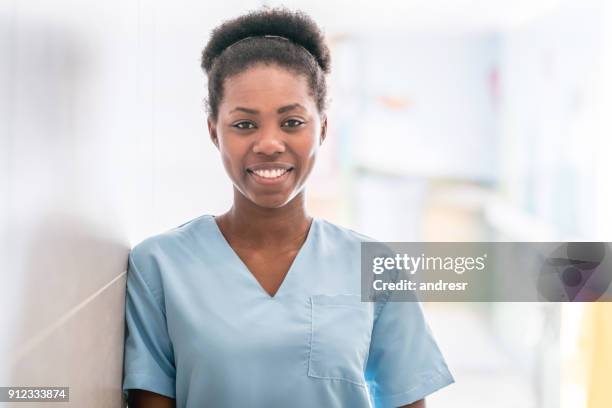 african american doctor wearing scrubs looking at camera smiling - uniforme hospitalar imagens e fotografias de stock