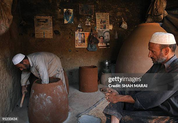 An Afghan man makes 'tandur' ovens at his shop in Kabul on September 29, 2009. Despite a flood of billions of dollars in aid provided by the...