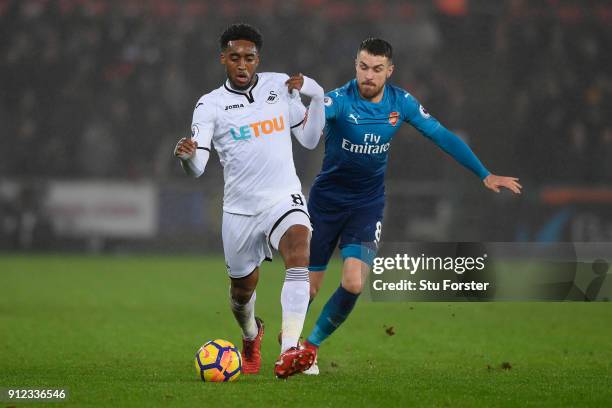 Leroy Fer of Swansea City and Aaron Ramsey of Arsenal battle for possession during the Premier League match between Swansea City and Arsenal at...