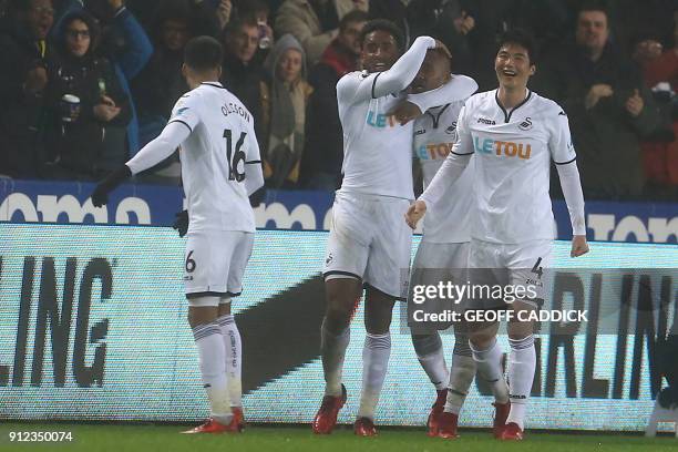 Swansea City's Ghanaian striker Jordan Ayew celebrates with teammates after scoring their second goal during the English Premier League football...