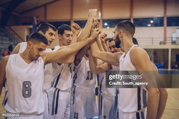 joueurs de basket-ball se blottir avant match - équipe de basket ball photos et images de collection