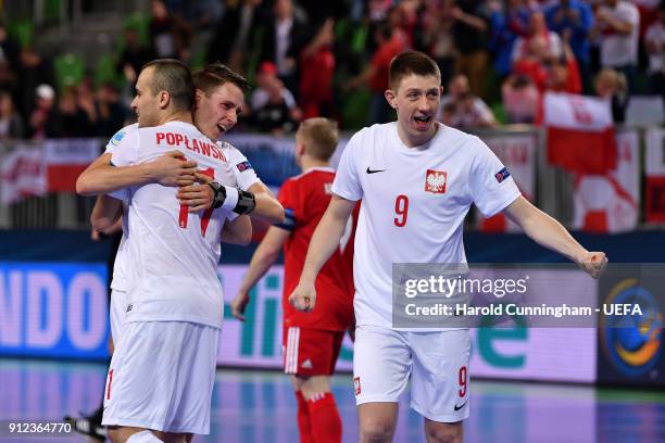 Mikolaj Zastawnik, Artur Poplawski and Tomasz Lutecki of Poland celebrate their victory during the UEFA Futsal EURO 2018 group B match between Russia...