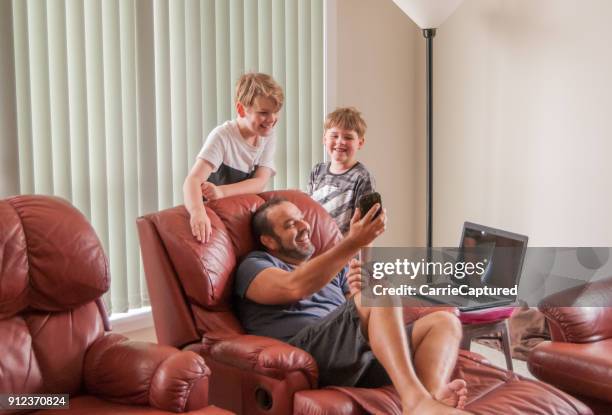 los niños mirando en el dispositivo que hombre relajarse en tumbonas - sillón reclinable tipo de silla fotografías e imágenes de stock