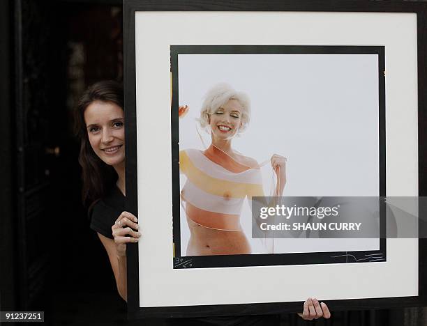 Lyon and Turnbull employee poses with one of the last photographs taken of Marilyn Monroe 'Marilyn Monroe in Stripe Scarf ' by Bert Stern during a...