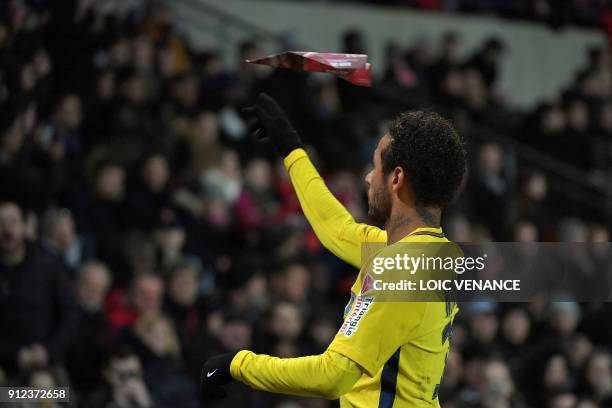 Paris Saint-Germain's Brazilian forward Neymar plays a paper plane at the end of the French League Cup football semi-final match between Rennes and...