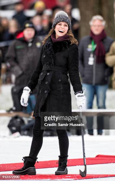 Catherine, Duchess of Cambridge reacts after hitting the ball as she attends a Bandy hockey match with Prince William, Duke of Cambridge, where they...