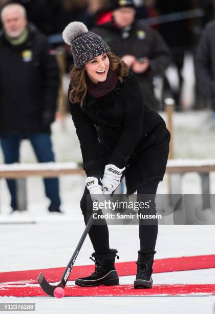 Catherine, Duchess of Cambridge hits a ball as she attends a Bandy hockey match with Prince William, Duke of Cambridge, where they will learn more...