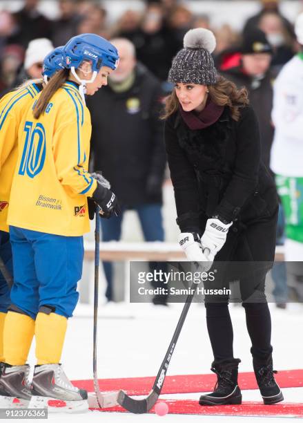 Catherine, Duchess of Cambridge hits a ball as she attends a Bandy hockey match with Prince William, Duke of Cambridge, where they will learn more...