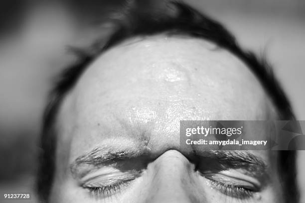 uomo strizzare gli occhi - forehead foto e immagini stock
