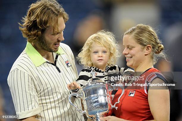 Kim Clijsters of Belgium with the championship trophy alongside husband Brian Lynch and daughter Jada after defeating Caroline Wozniacki of Denmark...