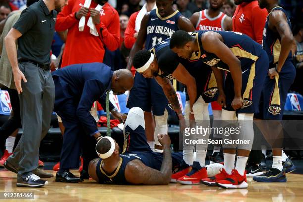 Players stand around DeMarcus Cousins of the New Orleans Pelicans after he injured his ankle during a NBA game against the Houston Rockets at the...