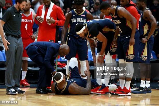 Players stand around DeMarcus Cousins of the New Orleans Pelicans after he injured his ankle during a NBA game against the Houston Rockets at the...