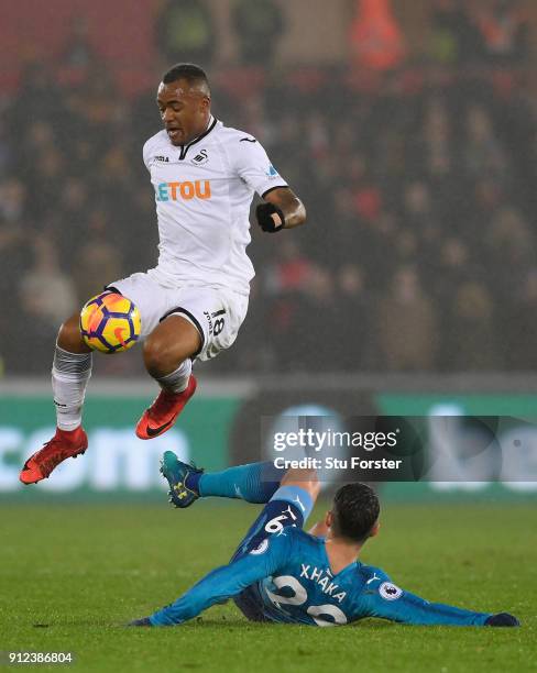 Swansea forward Jordan Ayew skips the challenge of Arsenal player Granit Xhaka during the Premier League match between Swansea City and Arsenal at...
