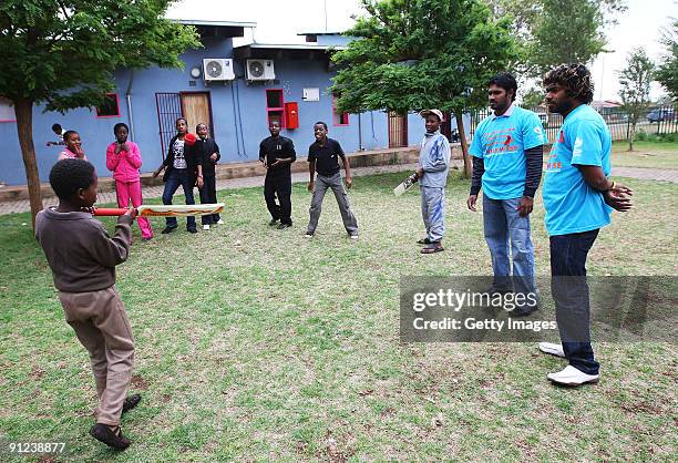 Chamara Kapugedera and Lasith Malinga of Sri Lanka play cricket with children during a THINK WISE visit to WITSECHO Adolescent Sprint Holiday...