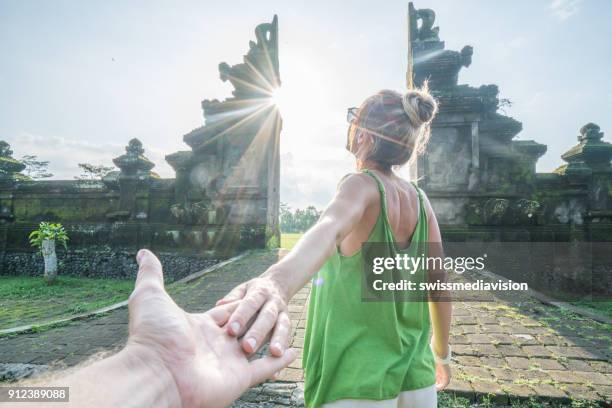 follow me to bali, woman inviting man holding hands, travel indonesia - bali travel imagens e fotografias de stock