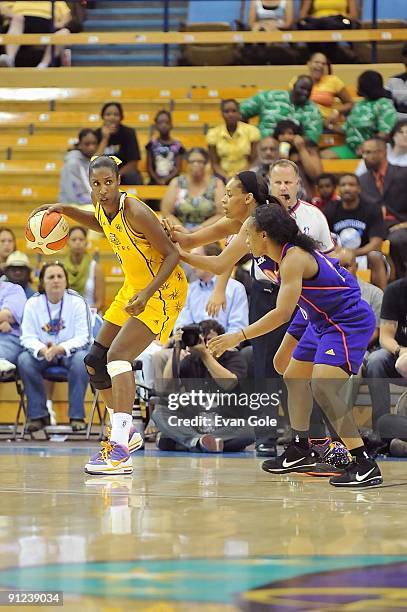 Lisa Leslie of the Los Angeles Sparks drives the ball against Tangela Smith and Temeka Johnson of the Phoenix Mercury in Game One of the Western...